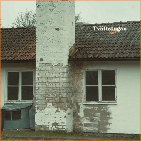 Barnbyns tvättstuga, ett vitt stenhus med skorsten och sliten fasad.